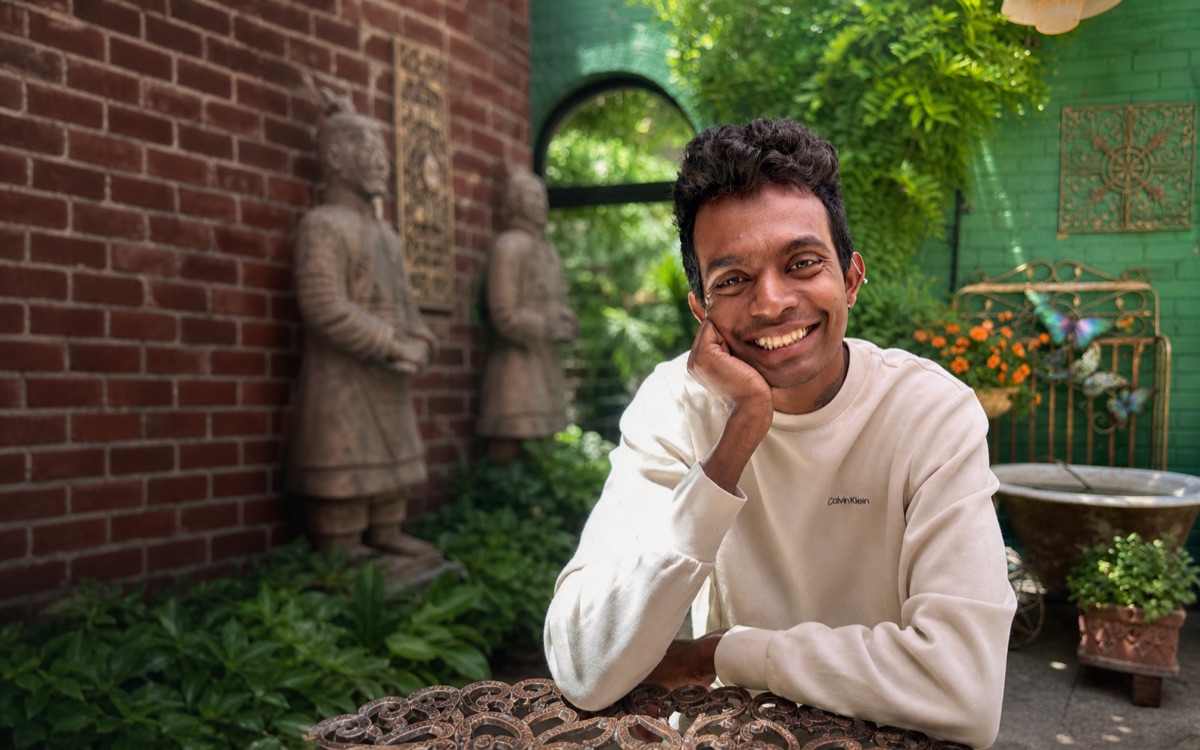 Asanka smiling in a garden cafe setting