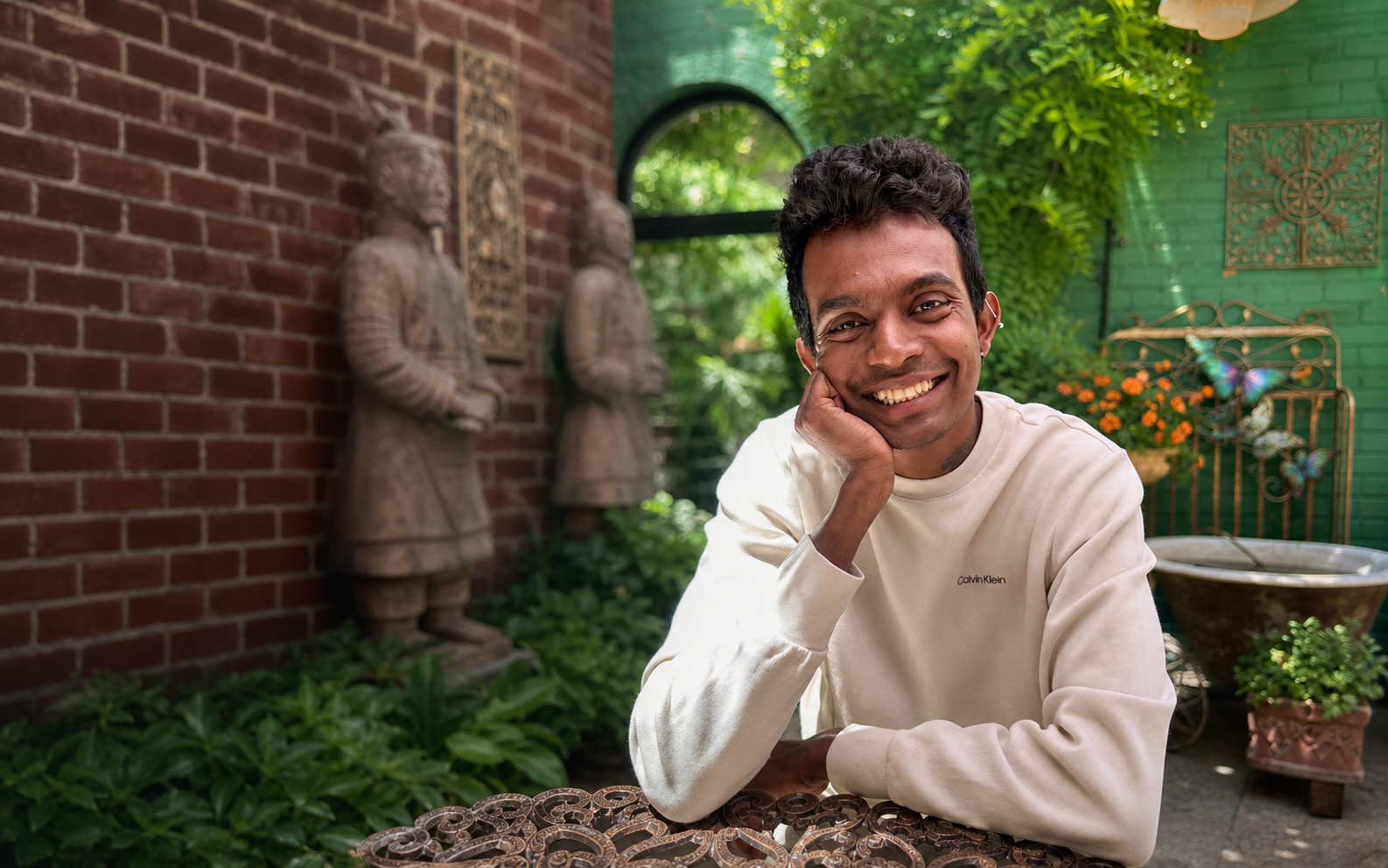 Asanka smiling in a garden cafe setting
